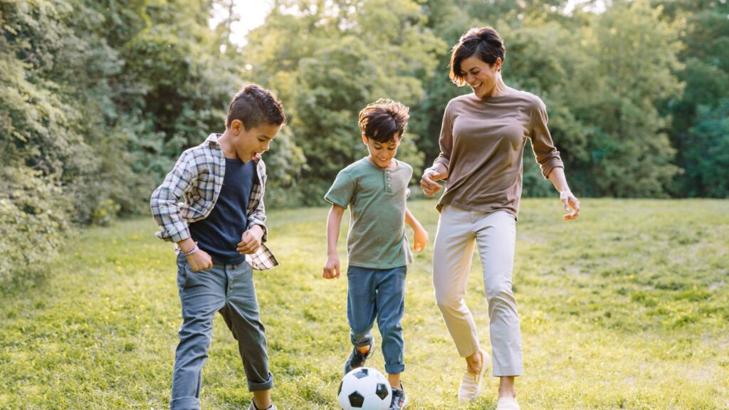 A woman joyfully enjoying soccer time with her children as Mother's Day gift.